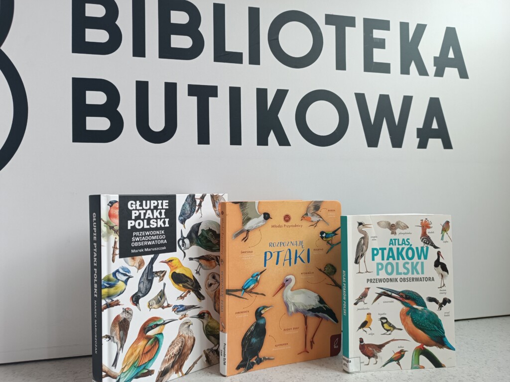 Zdjęcie trzech książek o ptakach na tle ściany z nazwą biblioteki