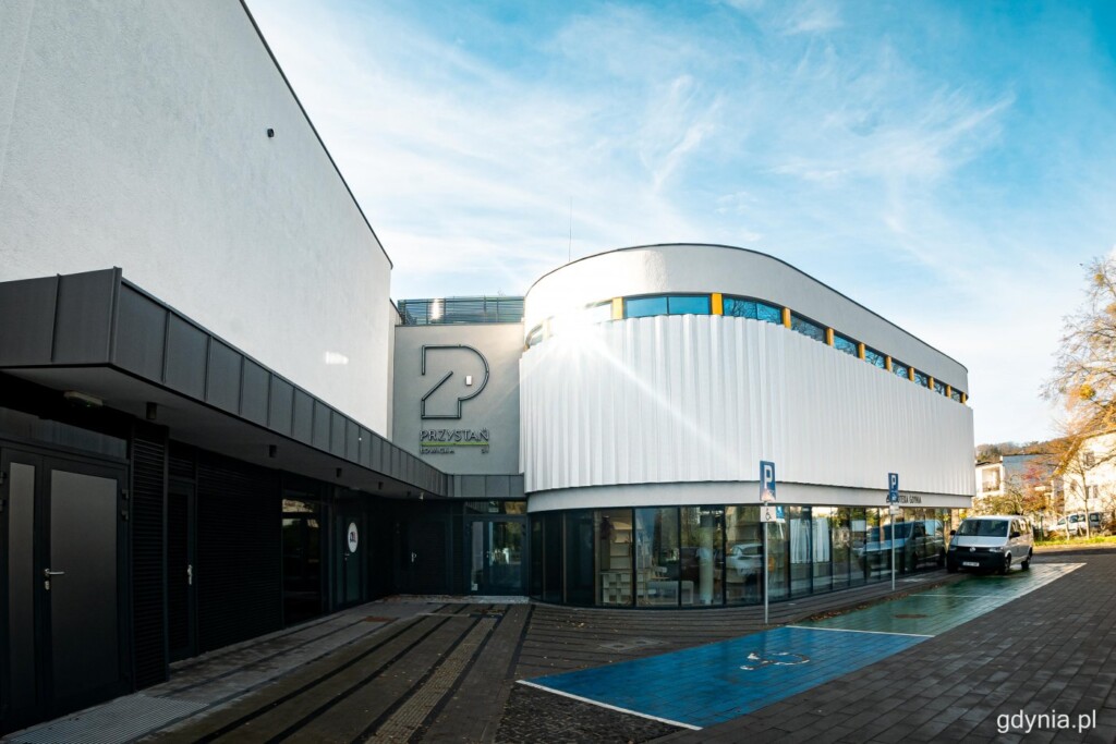 Przystań Łowicka 51. Nowoczesny, dwupiętrowy budynek. Na dole przeszklony, u góry z białą elewacją.