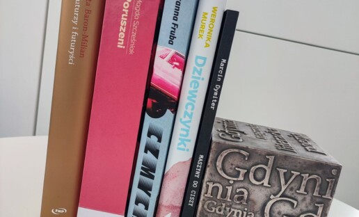 Zdjęcie przedstawia pięć stojących książek opartych o kostkę-nagrodę Nagrody Literackiej Gdynia, której widoczną ściankę pokrywają artystycznie rozmieszczone i różnej wielkości słowa "Gdynia".
