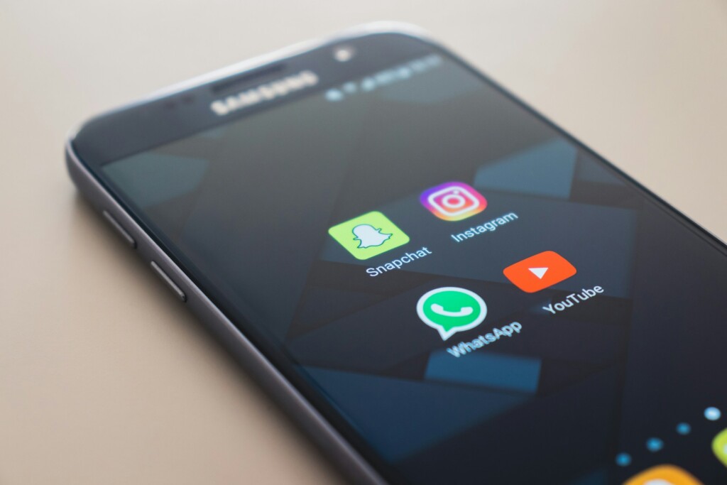 Telefon z podświetlonym ekranem. Na pulpicie widać ikonki popularnych aplikacji