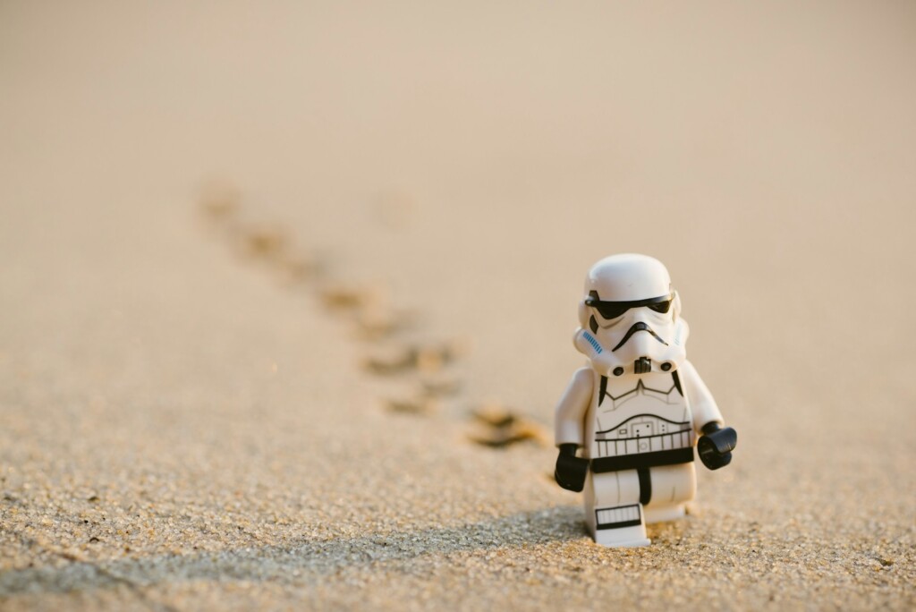 Figurka Lego Szturmowca ze Star Wars idącego po piasku i zostawiającego ślady.
