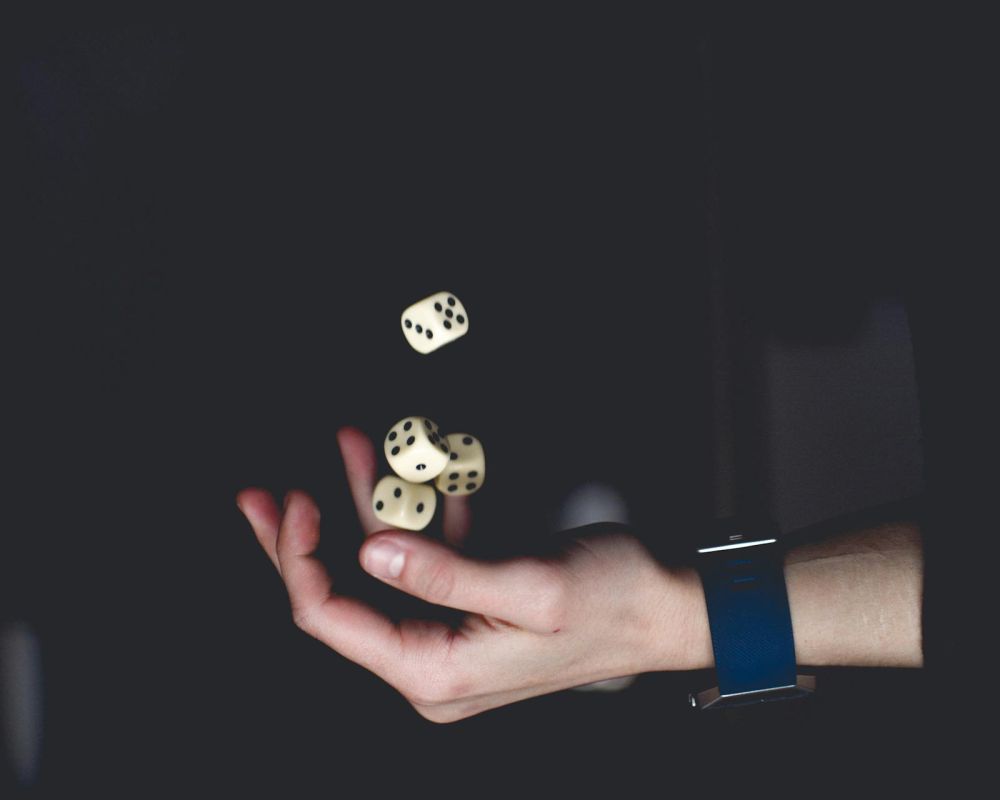 Ręka podrzucająca kostki do gry