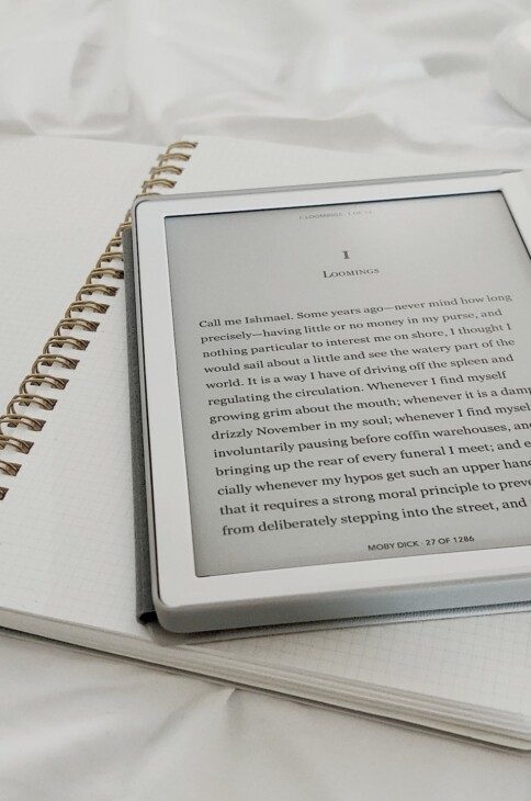 Czytnik ebook&oacute;w leżący na otwartym zeszycie.