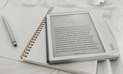 Czytnik ebooków leżący na otwartym zeszycie.