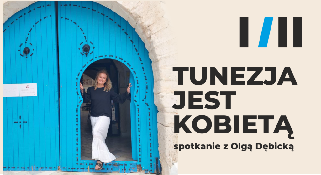 Olga Dębicka wypatruje zza niebieskiej bramy w budynku z kamienia