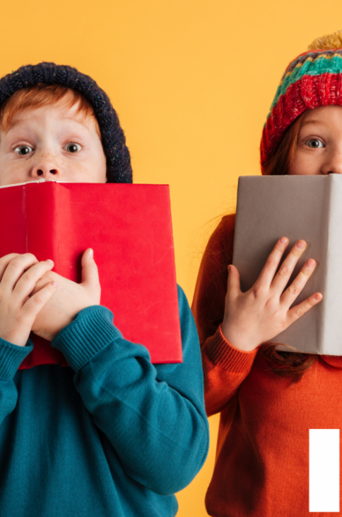 Zdjęcie dwóch dzieci chowających się za otwartymi książkami