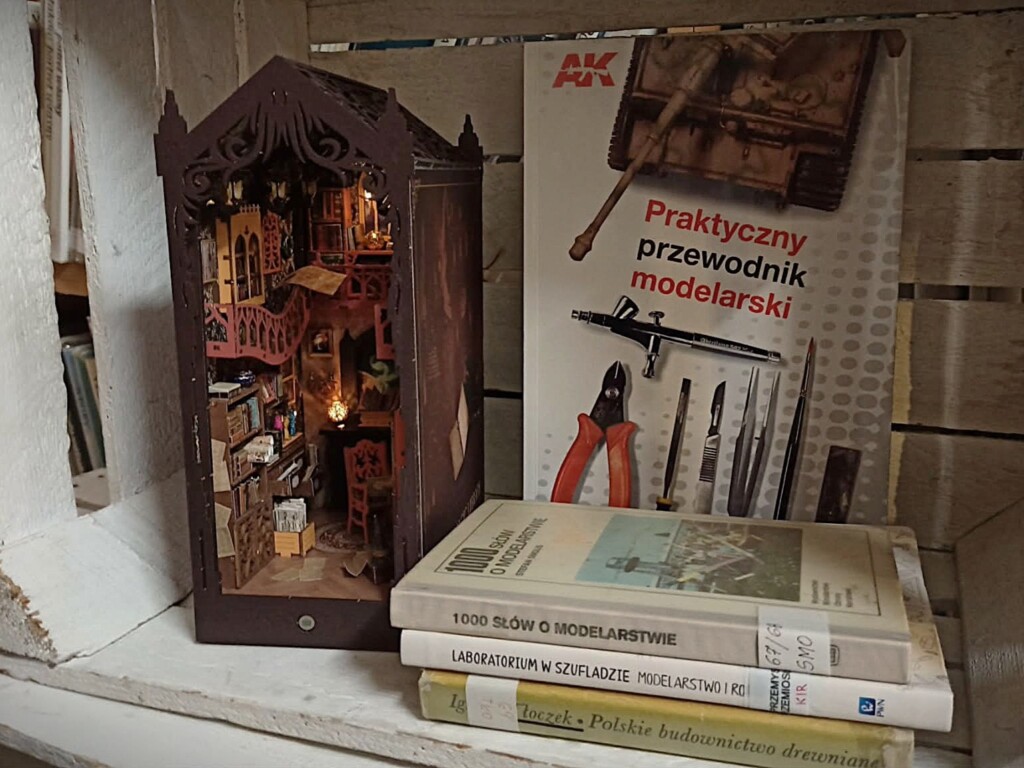 Zdjęcie modelu małej biblioteczki z wyeksponowaną książką "Praktyczny przewodnik modelarski".