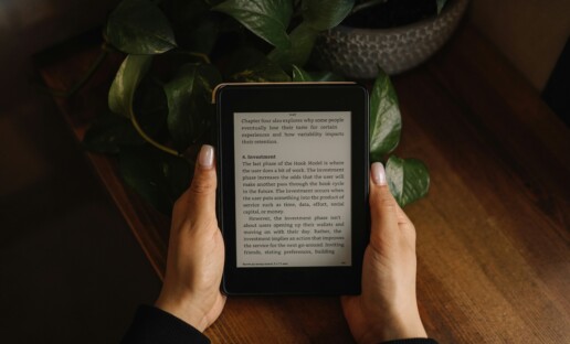 Dłonie trzymające czytnik ebooków.